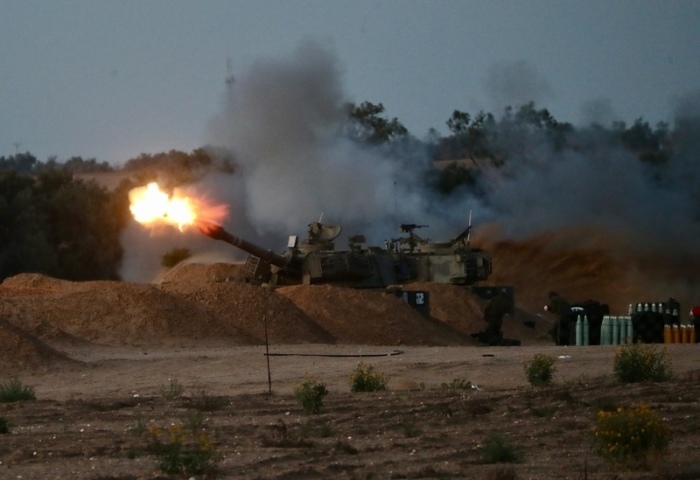 Eine israelische Panzerhaubitze feuert in der Nähe des Kerem Shalom Grenzübergangs im Süden Israels eine Granate auf den Gazastreifen ab. Foto: Jamal Awad/Xinhua/dpa
