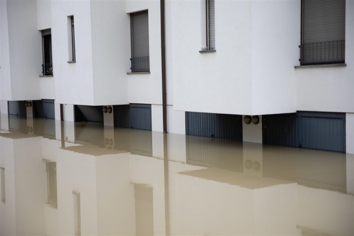 Die Fassaden eines Wohnhauses mit teilweise überfluteten Garagen spiegeln sich im Hochwasser in Castel Bolognese. Foto: epa/Max Cavallari