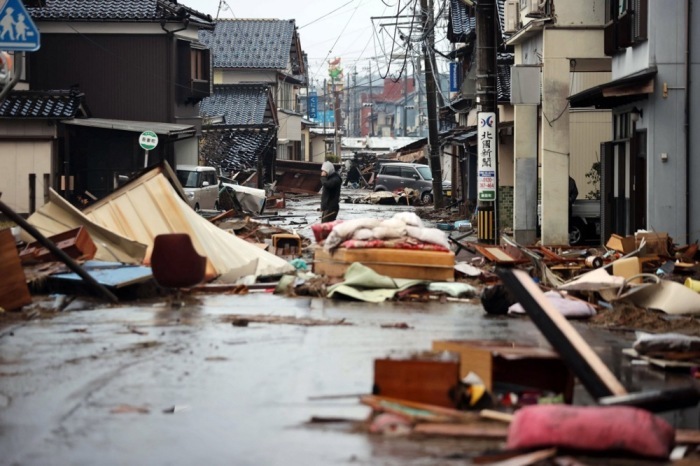 In Suzu, Präfektur Ishikawa, steht ein Mann in einer Straße, die nach einem Erdbeben mit den Trümmern eingestürzter Häuser bedeckt ist. Foto: epa/Jiji Press Japan Out Editorial Use Only