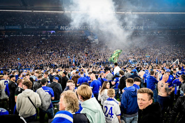 Die Schalke-Fans feiern nach dem Gewinn der deutschen Bundesliga auf dem Spielfeld. Foto: epa/Sascha Steinbach