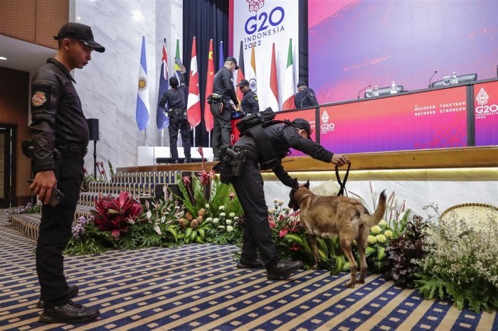 Mitarbeiter der Sicherheitskräfte des Präsidenten mit einem Spürhund inspizieren das Podium an einem der Veranstaltungsorte des G20-Gipfels in Nusa Dua, Bali. Foto: epa/Mast Irham