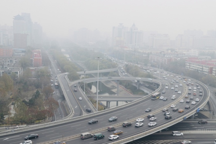 Autos fahren auf einer Straße, während starker Smog über der Stadt hängt. Die Feinstaubbelastung ist für Menschen weltweit nach wie vor sehr groß. Foto: Song Jiaru/Sipa Asia/sipa Asia Via Zuma Press Wire/dpa