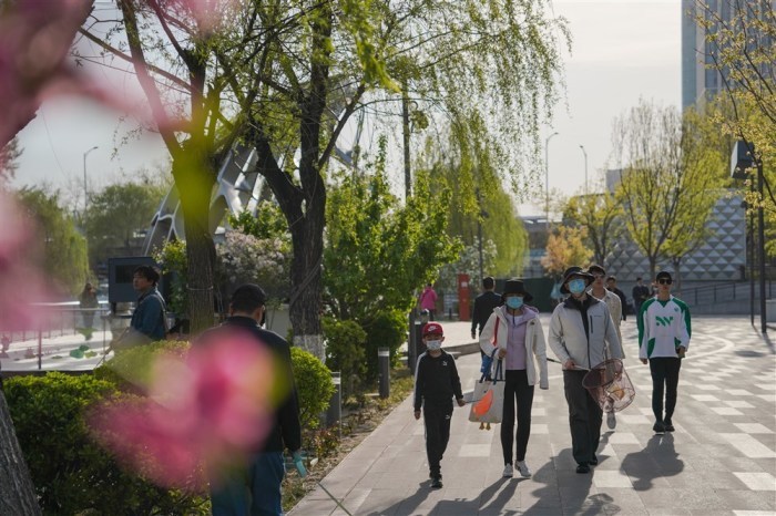 Personen mit Gesichtsmasken gehen in Peking spazieren. Foto: epa/Wu Hao