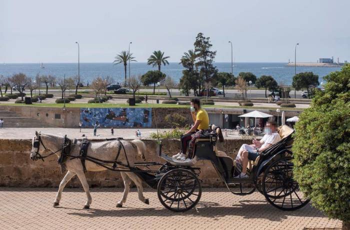 Die Touristen genießen eine Fahrt mit einer Pferdekutsche am Karfreitag in Palma de Mallorca. Foto: epa/Atienza