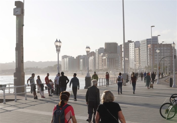 Besucher genießen die Promenade des Strandes von San Lorenzo in Gijon. Foto: epa/Jl Cereijido