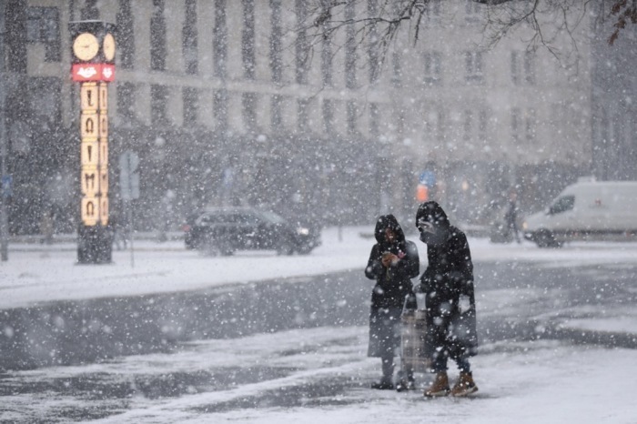 Leute gehen bei Schneefall in Riga spazieren. Foto: epa/Toms Kalnins