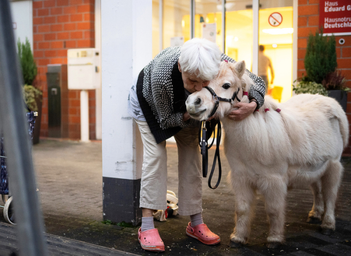 Bewohnerin Christine Müller umarmt vor der Pflegeeinrichtung Bürgermeister-Gräf-Haus zum Abschied das Shetland-Pony Toffee. Foto: Sebastian Gollnow/dpa