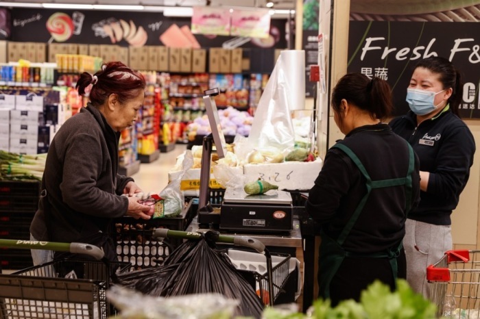 Mitarbeiter in einem Supermarkt in Peking. Foto: epa/Wu Hao