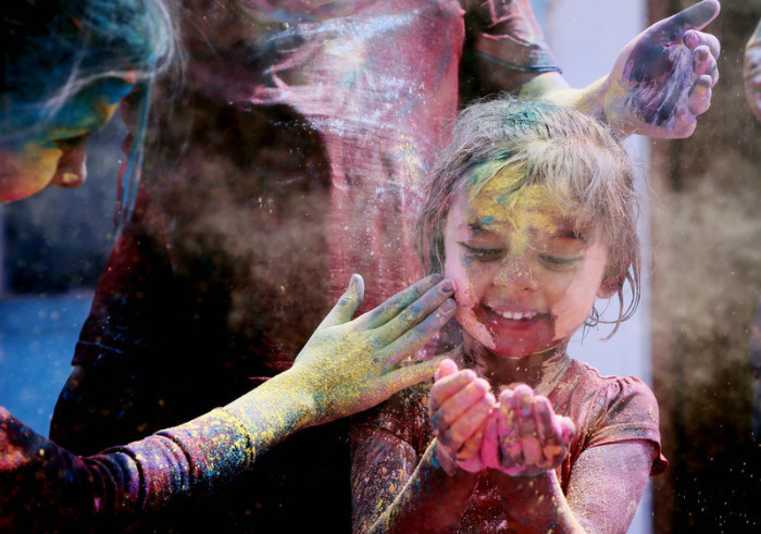 Ein Kind spielt mit farbigem Pulver während der Feierlichkeiten zum Holi Fest. Das Holi Fest markiert den Beginn des Frühlings und den Triumph des Guten über das Böse. Foto: Str/Xinhua/dpa