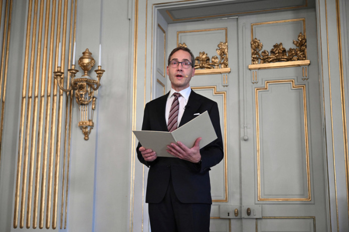 Der Sekretär der Schwedischen Akademie, Mats Malm, verkündet in Stockholm die Literaturnobelpreisträgerin Han Kang. Foto: dpa/Jessica Gow