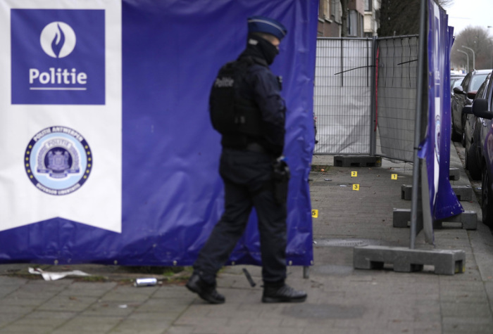 Ein Polizeibeamter geht nach Schüssen im Antwerpener Stadtteil Merksem vor forensischen Markierungen. Foto: Virginia Mayo/Ap/dpa