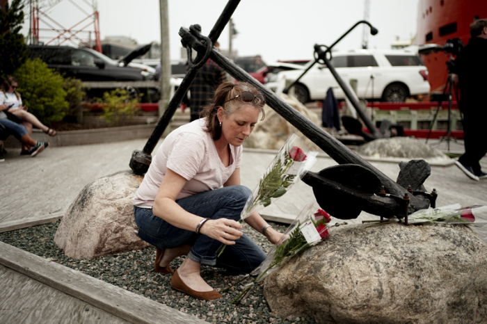 Die in St. John's lebende Patsy Power legt Blumen an einem Anker am King's Beach im Hafen von St. John's nieder. Foto: Jordan Pettitt/Pa Wire/dpa