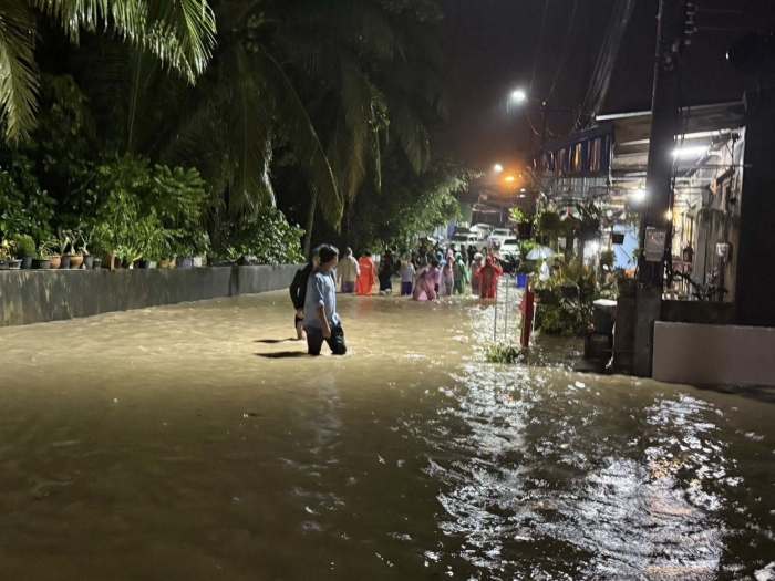Bild 1: Bewohner waten in der Nacht durch überflutete Straßen, nachdem starke Regenfälle mehrere Gemeinden im Süden Thailands unter Wasser gesetzt hatten. Bild: DDPM
