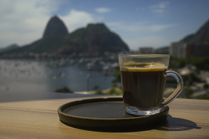 Eine Kaffeetasse steht an der Theke eines Cafés mit Blick auf das Meer und den Zuckerhut. Foto: Andre Borges/dpa