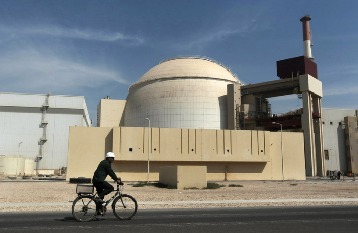 Ein Mann fährt mit dem Fahrrad an dem Reaktorgebäude des Kernkraftwerks Bushehr vorbei. Foto: Majid Asgaripour/Ap/dpa