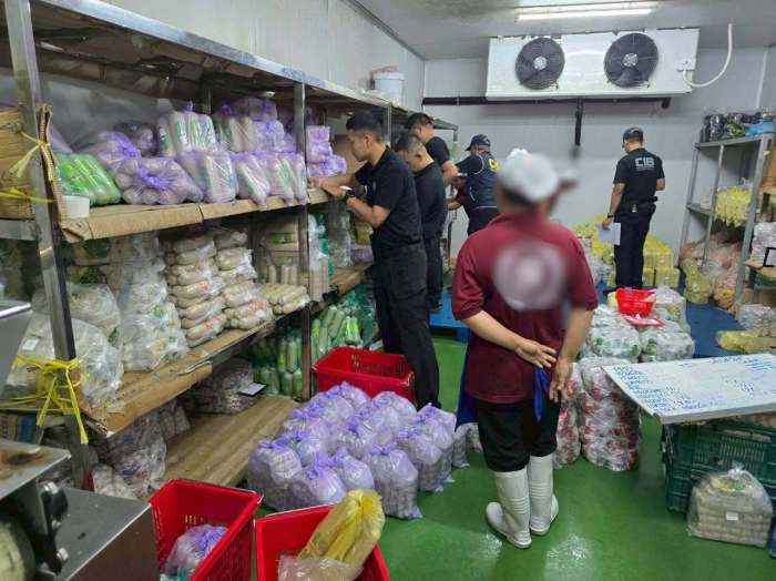 Beamte der Verbraucherschutzpolizei und weiterer Behörden überprüfen Produkte und Unterlagen während der Durchsuchung der Fleischfabrik. Bild: FDA Thailand