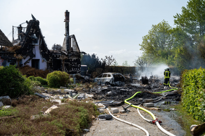 Die Feuerwehr arbeitet am Brandort. Nach einer Explosion ist in Putgarten im Norden der Insel Rügen am Morgen ein Feuer ausgebrochen und hat mehrere Häuser zerstört. Foto: Stefan Sauer/dpa