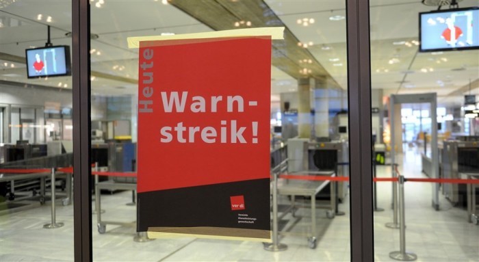 Im Bereich der Sicherheitskontrolle am Flughafen Stuttgart ist ein Plakat mit der Aufschrift 
