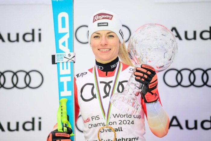 Die Schweizerin Lara Gut Behrami jubelt auf dem Siegerpodest des Gesamtweltcups der Damen beim Finale des FIS Alpinen Skiweltcups in Saalbach. Foto: EPA-EFE/Christian Bruna
