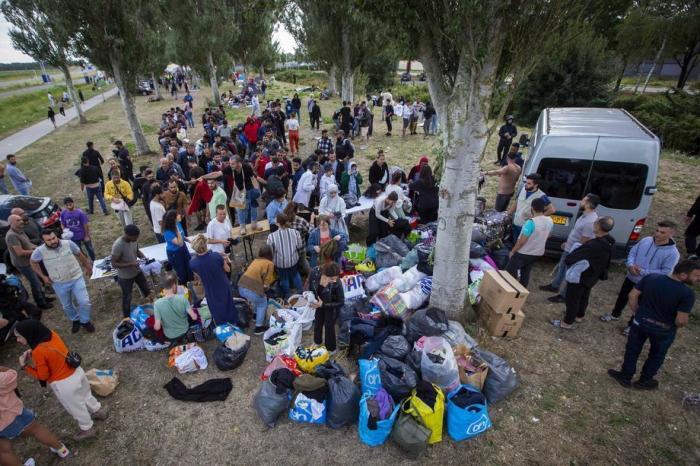 Freiwillige Helfer der islamischen Gemeinschaft Milli Gorus aus Rotterdam verteilen gesammelte Hilfsgüter an Asylbewerber im Antragszentrum in Ter Apel. Foto: epa/Vincent Jannink