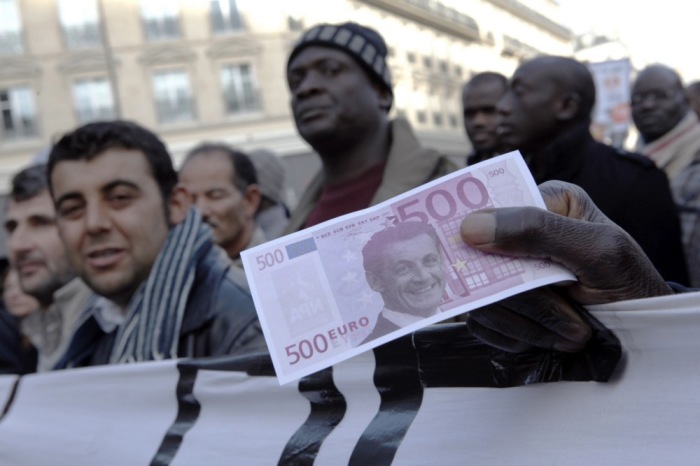 Ein Demonstrant zeigt einen gefälschten 500-Euro-Schein mit dem Gesicht des französischen Präsidenten Nicolas Sarkozy während einer Demonstration gegen die Rentenreform in Paris. Foto: EPA/Lucas Dolega