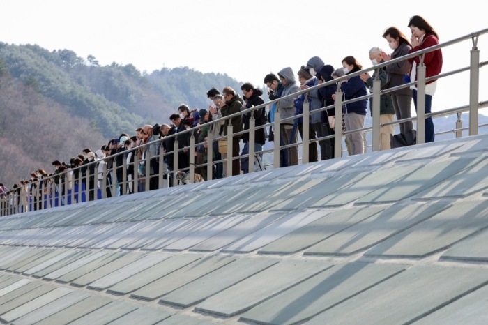 Menschen halten in Miyako eine Schweigeminute zum 15. Jahrestag des schweren Erdbebens und Tsunamis von 2011 in Nordostjapan. Foto: epa/Jiji Press