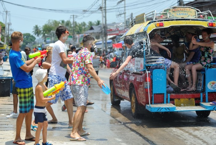 Touristen und Einheimische liefern sich während Songkran auf Koh Samui eine fröhliche Wasserschlacht entlang der Straße und nehmen sogar vorbeifahrende Songthaews ins Visier. Foto: Bangkok Airways