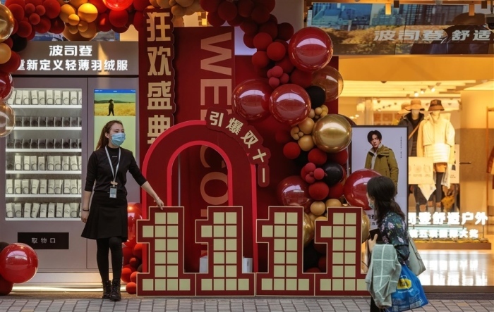 Ein Mitarbeiter eines Ladens wirbt für Rabatte zum Singles' Day in Shanghai. Foto: epa/Alex Plavevski