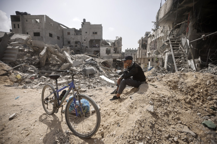 Ein Palästinenser sitzt inmitten der Zerstörung, nachdem die israelischen Streitkräfte Chan Junis im Gazastreifen verlassen haben. Foto: Mohammed Dahman/Ap/dpa