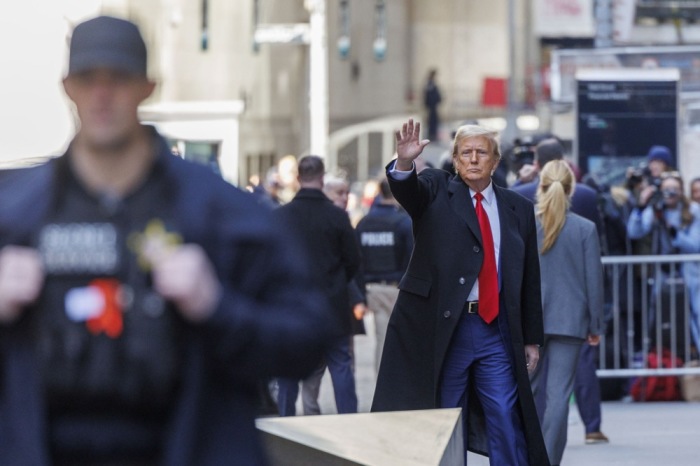 Der ehemalige US-Präsident Donald Trump (C) winkt den Zuschauern zu, als er die Wall Street 40 nach einer Pressekonferenz über seinen Fall vor einem Strafgericht in New York. Foto: EPA-EFE/Sarah Yenesel