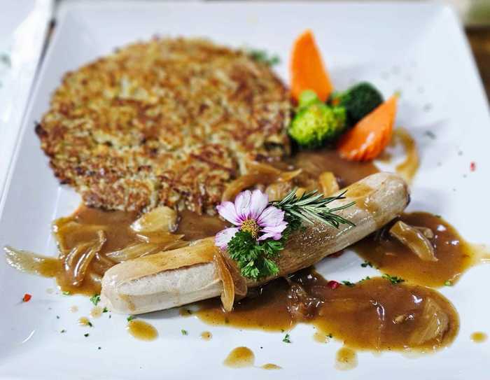Schweinsbratwurst mit feiner Zwiebelsauce, goldbraunem Rösti und Buttergemüse. Fotos: Jaybee'Swiss