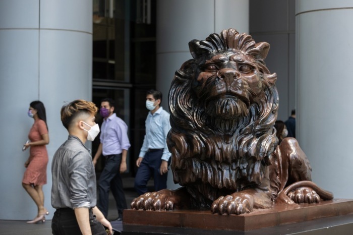 Spaziergänger gehen neben einer Löwenstatue am Hauptsitz der Hongkong and Shanghai Banking Corporation Limited (HSBC) in Hongkong. Foto: epa/Jerome Favre