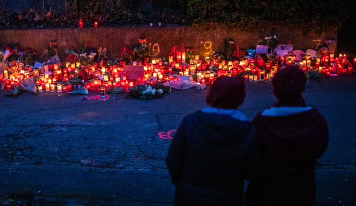 Zur blauen Stunde brennen zahlreiche Kerzen am Tatort eines Messerangriffs auf zwei Mädchen. Foto: Christoph Schmidt/dpa