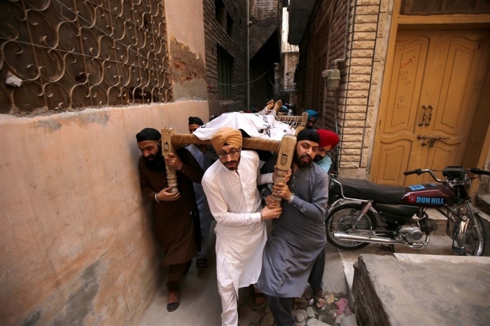 Mitglieder der Minderheit der Sikh-Gemeinschaft tragen die Särge von Angehörigen, die in Peshawar getötet wurden. Foto: epa/Arshad Arbab