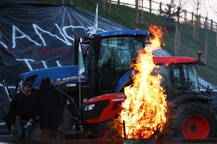 Neben einem Lagerfeuer blockieren Traktoren einen Teil der Autobahn A-15 bei Ableiges, nördlich von Paris. Foto: epa/Mohammed Badra