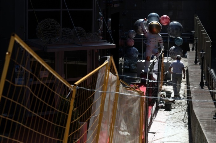 Ein Mann geht an einer Baustelle in der Moskauer Innenstadt an einem sonnigen Frühlingstag vorbei. Foto: EPA/Maxim Shipenkov
