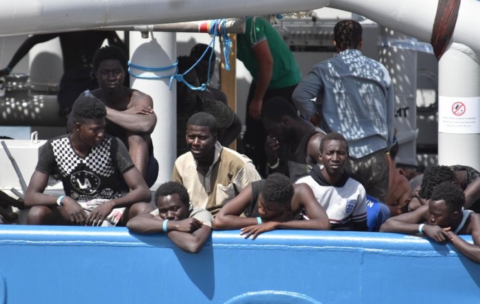  Migranten warten an Bord eines Schiffes im Hafen von Catania, Sizilien. Foto: epa/Orietta Scardino