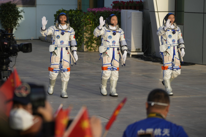Die chinesischen Astronauten der Shenzhou-16-Mission, Gui Haichao (l-r), Jing Haipeng und Zhu Yangzhu winken, als sie im Jiuquan Satellite Launch Center zu einer Abschiedszeremonie vor ihrer bemannten Weltraummis... Foto: Mark Schiefelbein/Ap/dpa