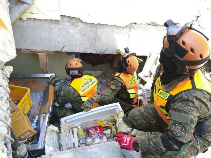 Rettungskräfte der philippinischen Armee durchsuchen ein eingestürztes Gebäude in General Santos City nach Überlebenden des schweren Erdbebens. Foto: epa/Philippine Army/handout