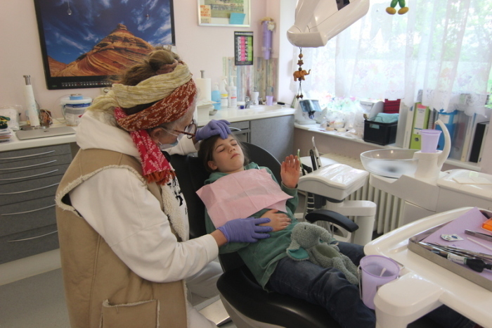 Die acht Jahre alte Elisa liegt auf einem Zahnarztstuhl in der Praxis von Ute Stein. Foto: Doreen Garud/dpa