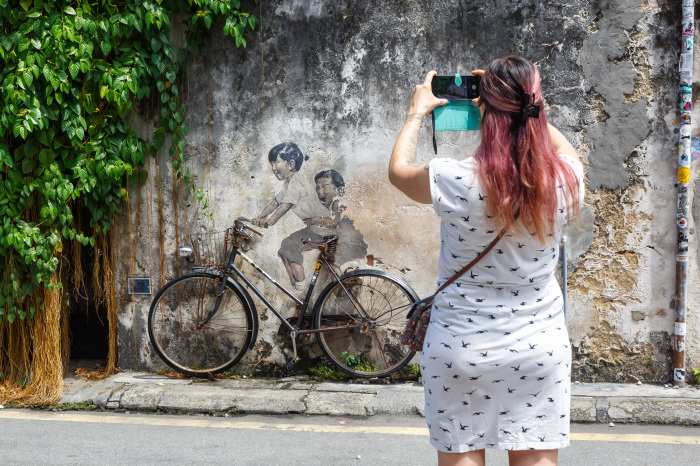Street-Art-Kunst „Junge und Mädchen auf Fahrrad“ an einer Mauer in George Town auf der Insel Penang in Malaysia. Foto: picture alliance/Markus Mainka | Markus Mainka
