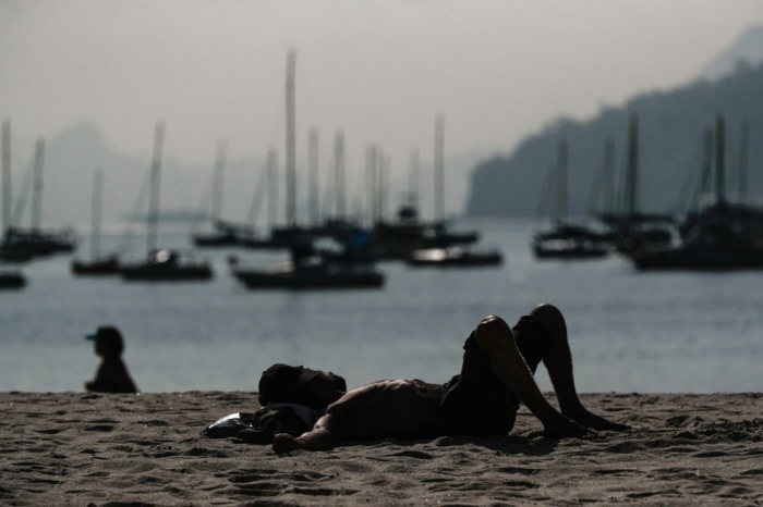 Ein Mensch ruht sich am Strand von Botafogo in Rio de Janeiro aus. Foto: epa/Andre Coelho