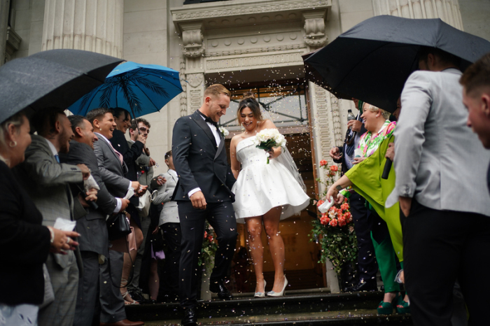 Das frisch verheiratete Paar Jack und Katie Webster schreitet die Stufen der Old Marylebone Town Hall in London hinunter, die ihr 100-jähriges Bestehen mit 100 Hochzeiten an einem Tag feiert. Foto: Yui Mok/Pa Wire/dpa