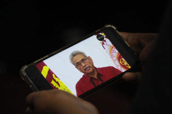 Person sieht sich auf einem Handy ein Video von Sri Lankas Präsident Gotabaya Rajapaksa an, der sich im Fernsehen an die Nation wendet, in Colombo. Foto: epa/Chamila Karunarathne