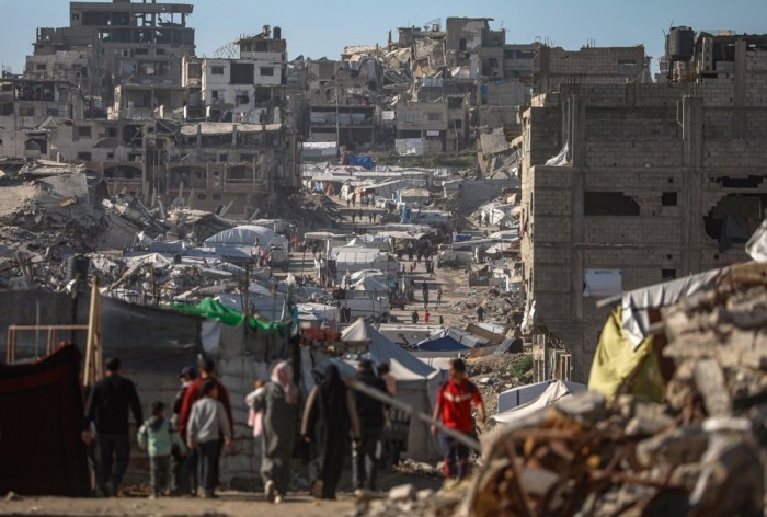 Vertriebene Palästinenser bewegen sich durch die zerstörten Straßen des Viertels Al-Tuffah in Gaza-Stadt während einer Waffenruhe. Foto: epa/Mohammed Saber