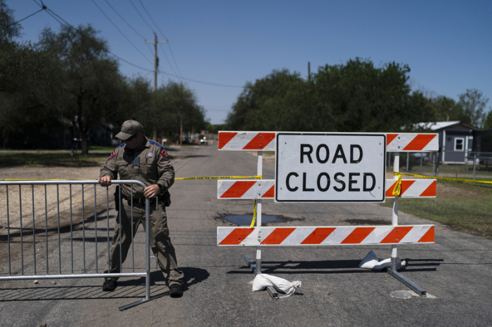 Ein Polizist baut eine Straßenabsperrung vor der Robb Elementary School auf. Ein 18-jähriger hat bei einem Amoklauf in einer Grundschule im US-Bundesstaat Texas mehrere Menschen getötet. Foto: Jae C. Hong