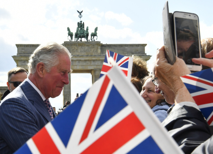 Der damalige britische Prinz Charles spricht zwischen britischen Fähnchen mit Schaulustigen am Brandenburger Tor bei seinem Besuch im Mai 2019. Foto: John Macdougall/Afp Pool/dpa