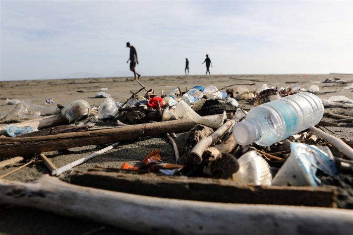 Menschen spazieren entlang eines mit Plastikmüll vermüllten Strandes am Beach. Foto: EPA-EFE/Hotli Simanjuntak Id: