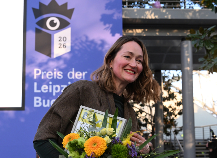 Autorin Katerina Poladjan erhält für „Goldstrand“ den Preis der Leipziger Buchmesse und verlässt mit Blumen die Bühne in Leipzig. Foto: Hendrik Schmidt/dpa
