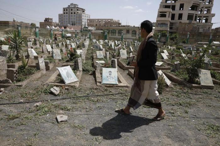 Ein Mensch geht auf einem Friedhof in Sana'a an Porträts auf den Gräbern derjenigen vorbei, die im aktuellen Krieg im Jemen getötet wurden. Foto: epa/Yahya Arhab
